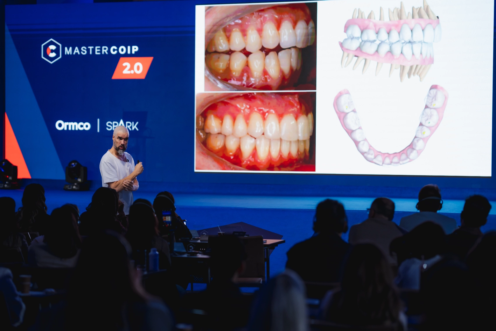 Dr. Iván Malagón teaching a MasterCOIP class next to the screen showing two clinical cases